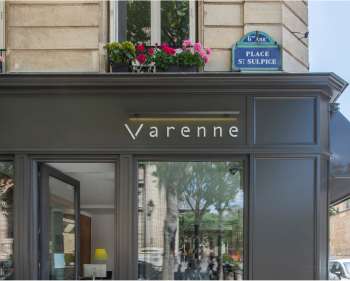 Photo devanture agence immobilière Varenne et plaque place st sulpice 6eme arrondissement paris avec un balcon fleuri