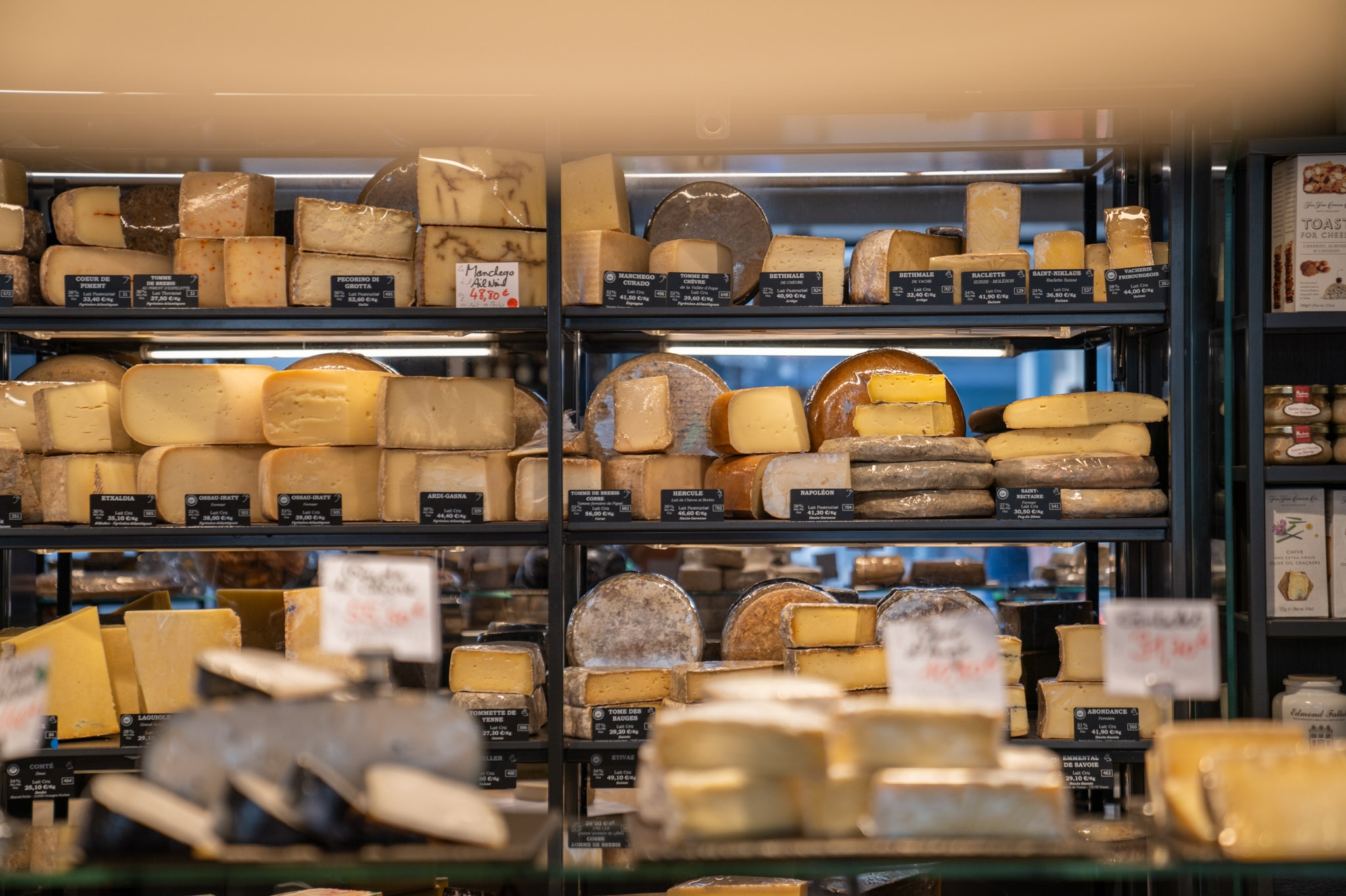 Boutique Fromager - Affineur à Paris  avec étagères remplies de fromages