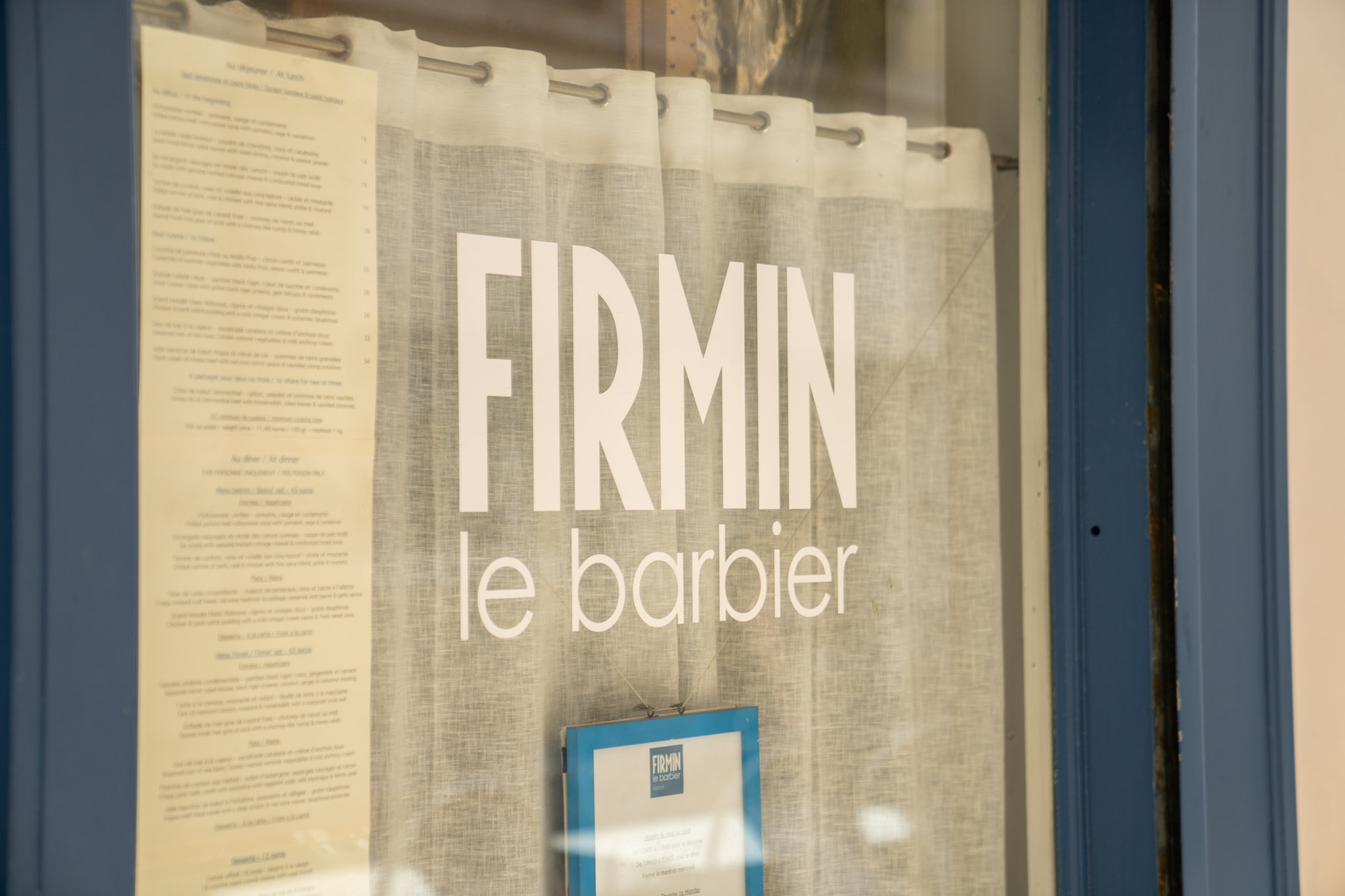Devanture rideau blanc fermés du barbier parisien firmin