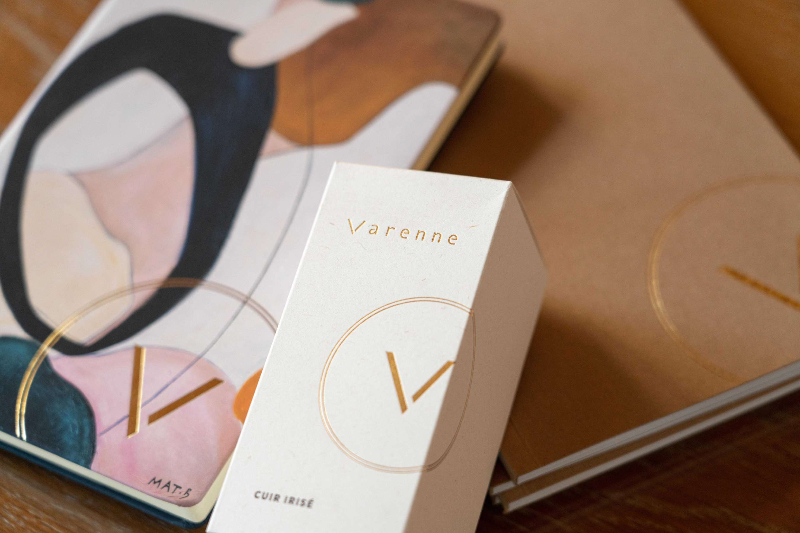 Packaging Parfum Varenne Cuir Irisé posé sur des carnets