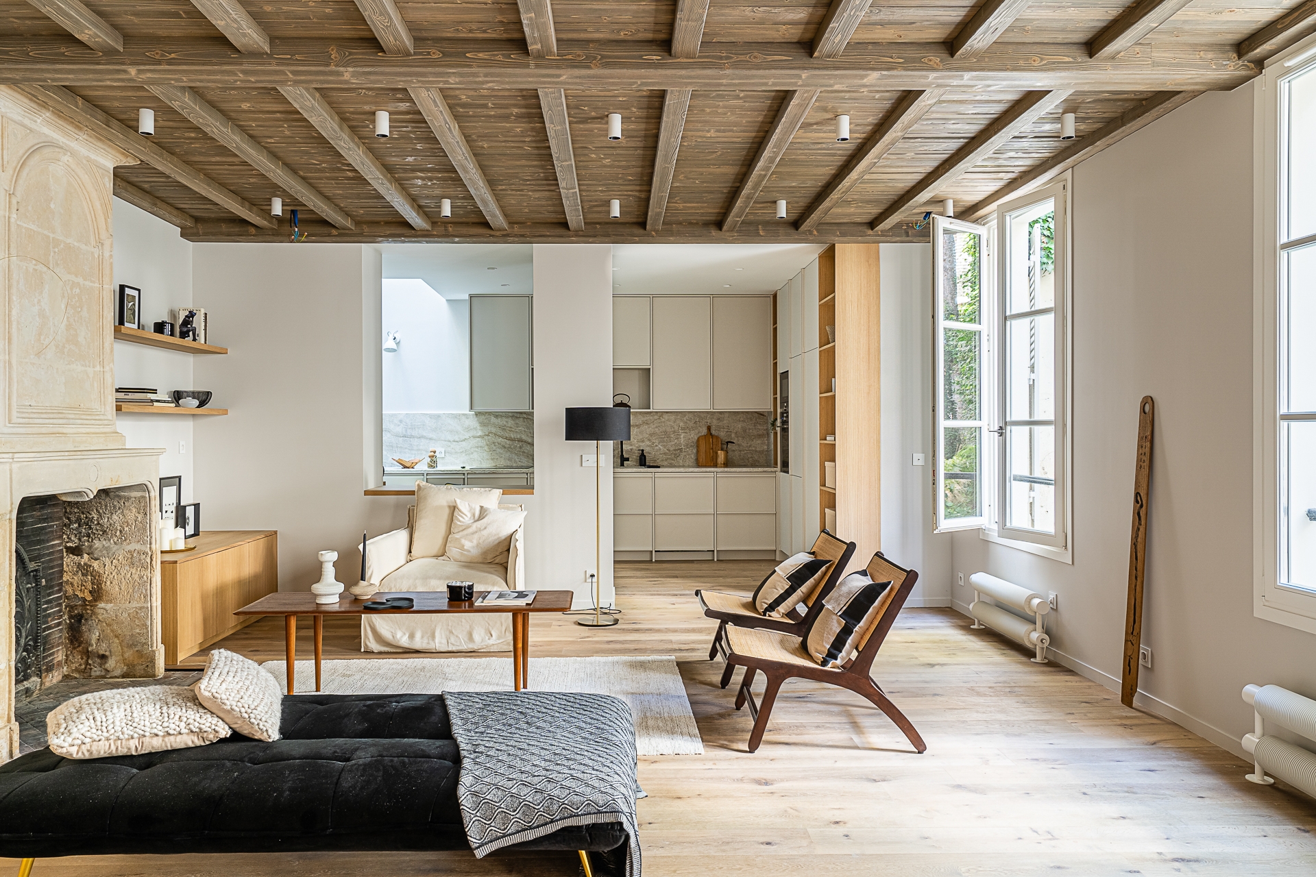 Intérierur décoration Salon cheminé en pierre et plafond de bois ouvert sur cuisine